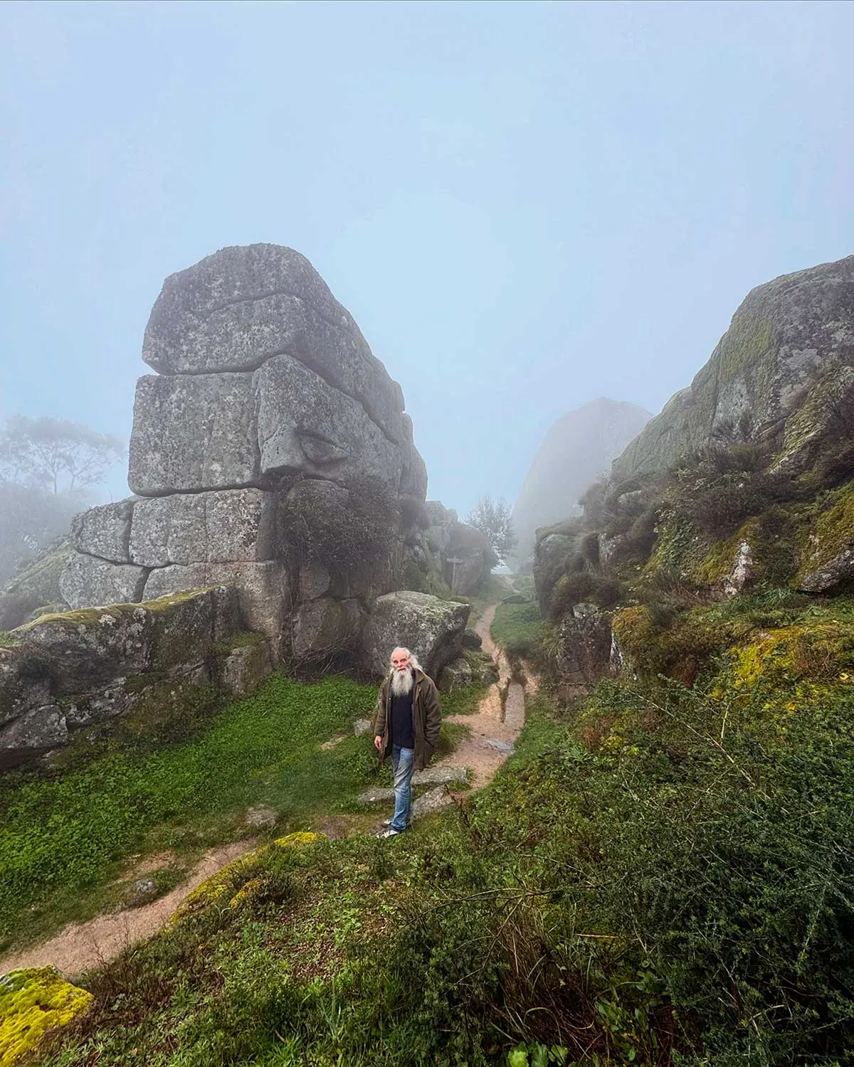 John Can Do standing on a misty path among the giant granite boulders of Monsanto